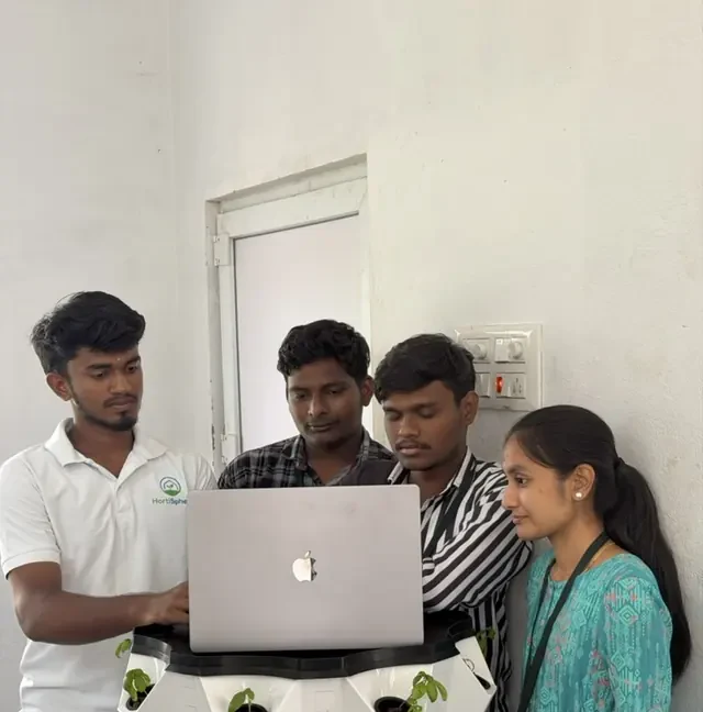 Greenzy's team reviewing sensor data from a hydroponic tower prototype
